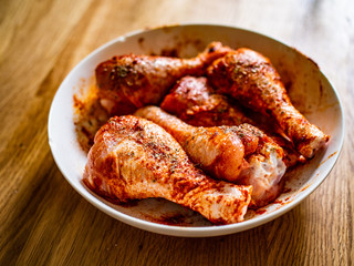 Marinated raw chicken drumsticks ready for grill