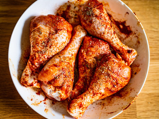 Marinated raw chicken drumsticks ready for grill