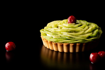 Tart with kiwi and whipped cream on black background wipes