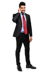 Attractive young businessman on mobile phone against white