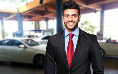 Car dealer smiling in a car saloon
