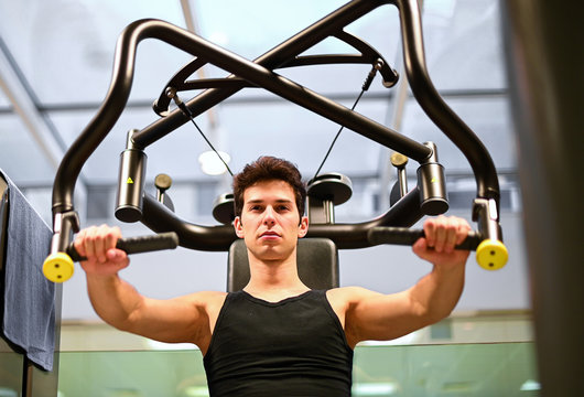 Young woman using a chest press machine - Stock Image - C047/0761