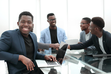 young businessman uses laptop sitting at office Desk.