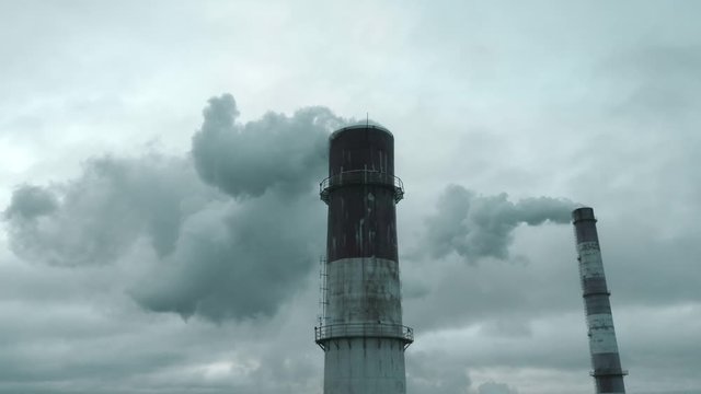 Heavy smoke coming from industrial smokestack pipes. Air pollution coming from chimney, aerial view. Concept for CO2 emissions, industrialization, climate crisis 