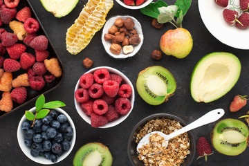 Ingredients for a healthy breakfast. Nutrition, granola, oatmeal, nuts, fruits, berries, kiwi, bananas, raspberries, blueberries, seeds, apples. A diet rich in vitamins and fiber. Top view.
