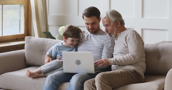 Friendly three age multi generation men family using laptop together