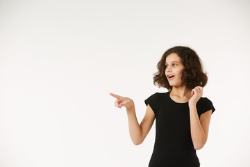 A girl in black clothes on a white background depicts the emotion