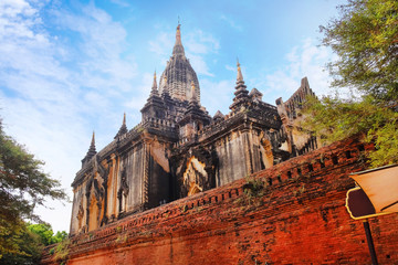 Blue sky above a temple surrounded by green vegetation in old Bagan, Myanmar.