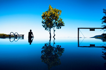 Man sitting at infinity pool overlooking the mountains and in high elevation on a clear day