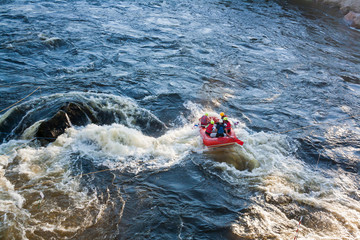 Obraz premium A group of men and women white water rafting on a river as extreme and fun sport