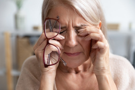 Close up of unhealthy old woman suffer from migraine