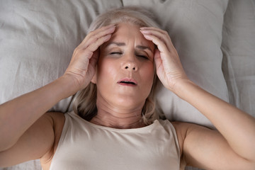 Top view of sick senior woman suffer from migraine