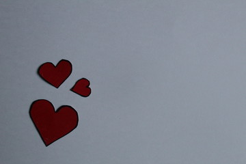 hearts are red with a black outline on a light background