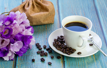 cup coffee, roasted coffee bean on blue table.