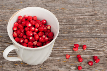 Fresh strawberries in white mug on brown wooden table