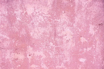 Fragment of old house wall close-up. Pink background. Peeling plaster on concrete surface. Cracks in paint. Copy space. Place for text. Selective focus image.