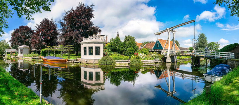 Kwakel draw bridge in the historic town Edam, Netherlands. Kwakel draw bridge is an old bridge with counter-balance construction. Calm view of the canal, waterfront houses and church tower
