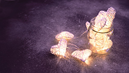 Obraz na płótnie Canvas Beautiful heart-shaped fairy lights glowing inside glass jar. St. Valentine's Day mood