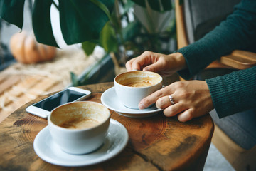 Estores personalizados con tu foto Girl drinks coffee in a cafe during a meeting. Nearby, a cell phone lies on a table.