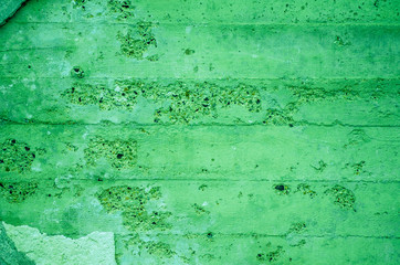 Fragment of old house wall close-up. Green background. Peeling plaster on concrete surface. tinted green. Cracks in paint. Copy space. Place for text. Selective focus image.