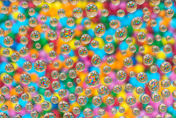 Colorful candiy reflected through water droplets on glass - textured background