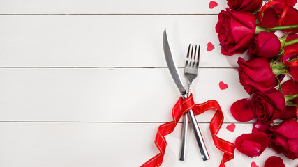 Celebration food background. Cutlery and roses on white wooden table