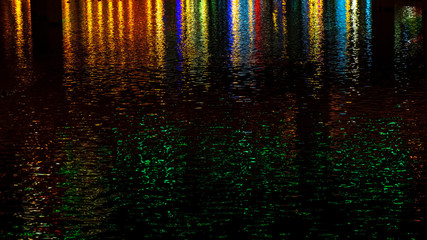 Multi-colored reflections on the river create a festive mood. Abstract background for birthday, anniversary, wedding, new year eve or Christmas