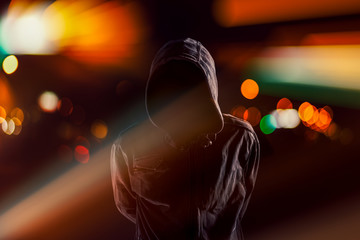 Hooligan with hoodie and obscured face at night