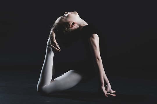 Young girl flexing her back touching toes to forehead for portrait