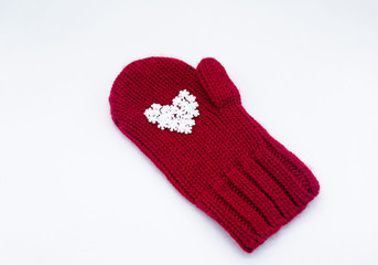 A knitted red mitten, on which white snowflakes in the shape of a heart lie as if in the palm of your hand on a white background, isolated. Сoncept of Christmas, winter, love, care and Valentine's day