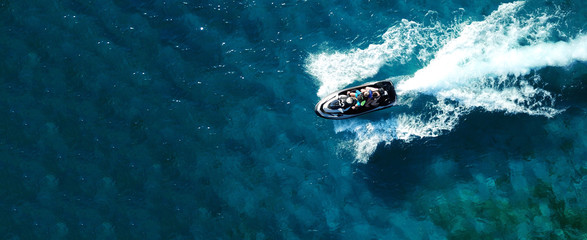 Aerial drone ultra wide photo of jet ski watercraft cruising in high speed in deep blue open ocean...