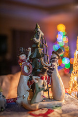 Naklejka premium Snowmen decorating a Chistmas Tree with boken from a real tree behind them