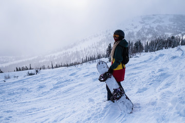 Fototapeta na wymiar Snowboarder woman on a snowy slope in mountains.