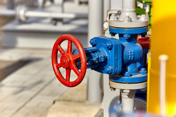 Blue valve on a yellow pipe at a gas processing plant