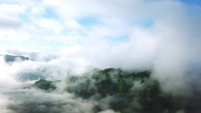 Flight in the clouds in mountains, morning clouds in the mountains aerial, aerial view of morning fog in mountains, Aerial view above the clouds and sky in sunrise time, Majestic clouds in the mountai