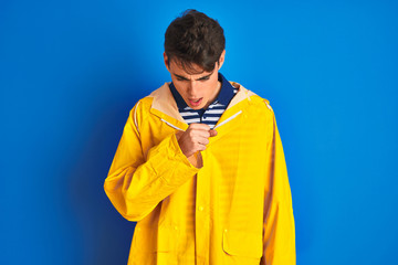 Fototapeta premium Teenager fisherman boy wearing yellow raincoat over isolated background feeling unwell and coughing as symptom for cold or bronchitis. Healthcare concept.