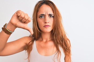 Fototapeta premium Young redhead woman stading over white isolated background with angry face, negative sign showing dislike with thumbs down, rejection concept