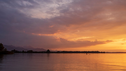 Sunset at lake Chiemsee against cloudy sky during golden hour
