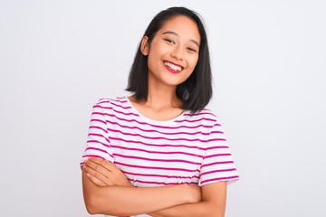 Young chinese woman wearing striped t-shirt standing over isolated white background happy face smiling with crossed arms looking at the camera. Positive person.