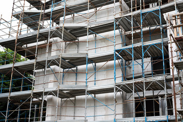 Building under construction in scaffolding. Construction site background. Europe, Italy.
