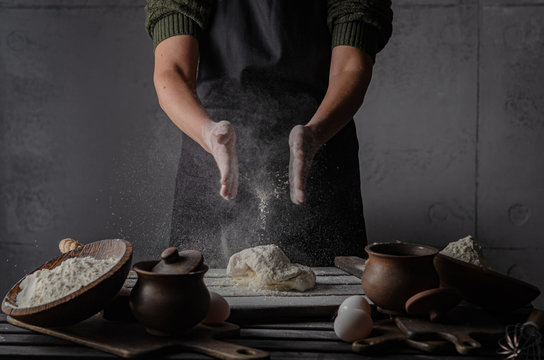 Thin graceful female hands a month dough. Dark Moody.