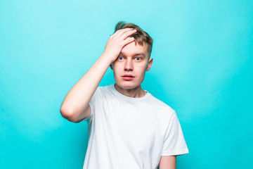 Young teen man forget something sranding isolated on green background