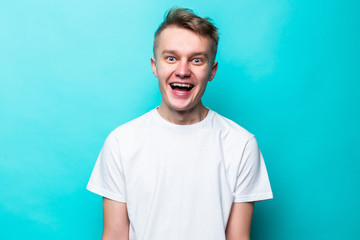 Obraz premium Close up portrait of cheerful smiling blond handsome young teen man isolated on green background