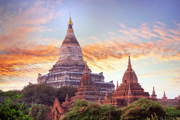 Colorful sunset sky above temples surrounded by green vegetation in old Bagan, Myanmar.