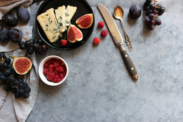Cheese plate with grapes, figs and berry. Wine snaks. Top view with copy space. Flat lay concept.