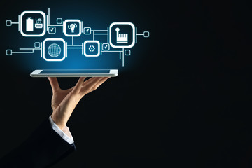 Businesswoman with tablet PC on dark background