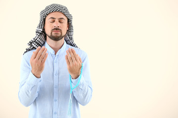 Muslim man praying against light background