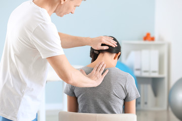 Fototapeta premium Physiotherapist working with female patient in rehabilitation center