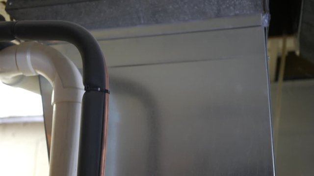 Panning up a furnace that leads into ceiling tiles in residential home basement