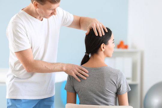 Physiotherapist working with female patient in rehabilitation center